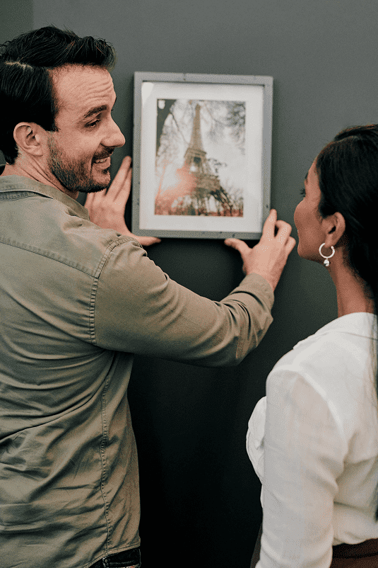 Man woman hanging picture